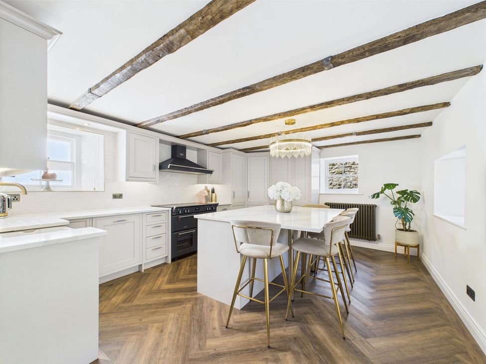 A kitchen with cabinets and a dining table at The Smithy in Barnard Castle