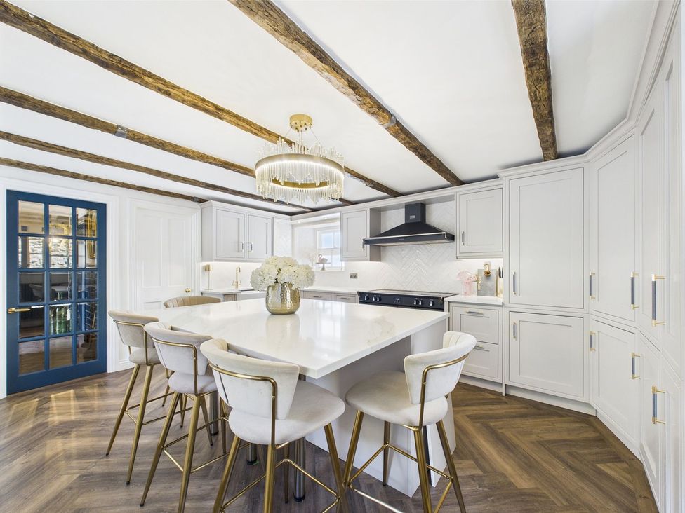 A kitchen with an island and bar stools at The Smithy in Barnard Castle