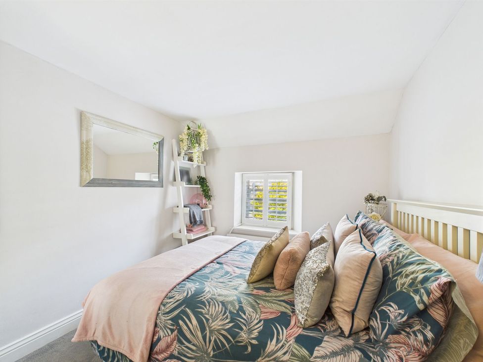 A bedroom with a bed and shelves at The Smithy Barnard Castle