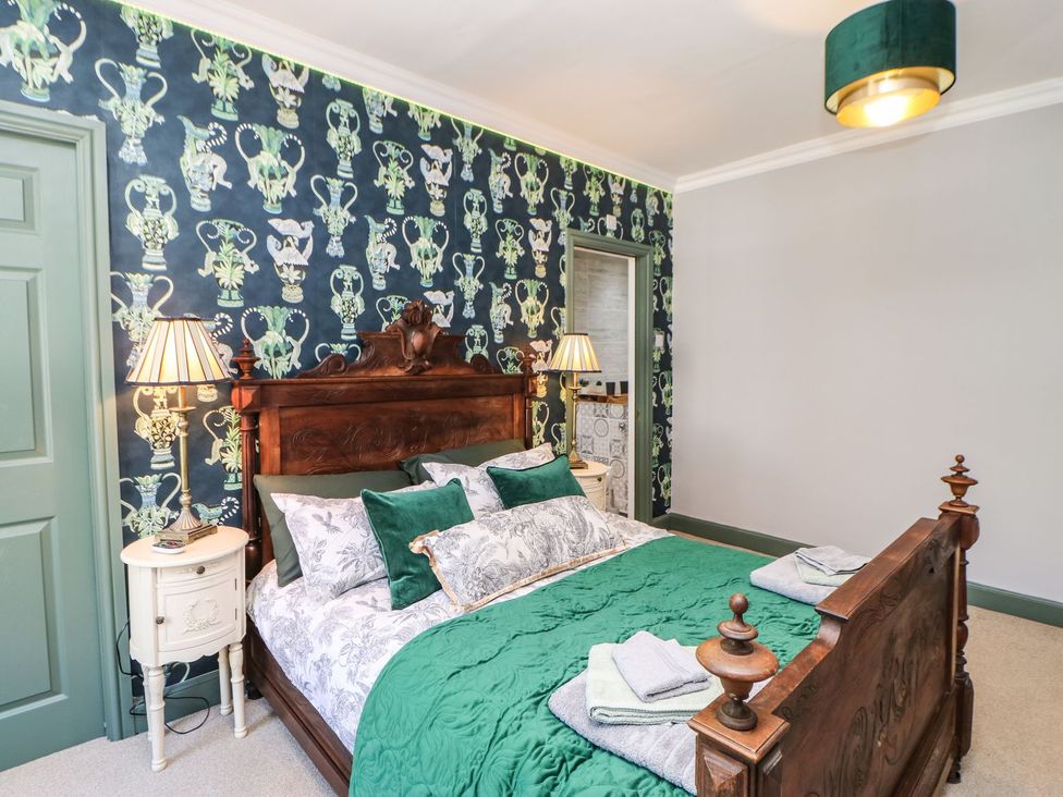 A bedroom with a wooden bed and bedside table at The Smithy in Barnard Castle