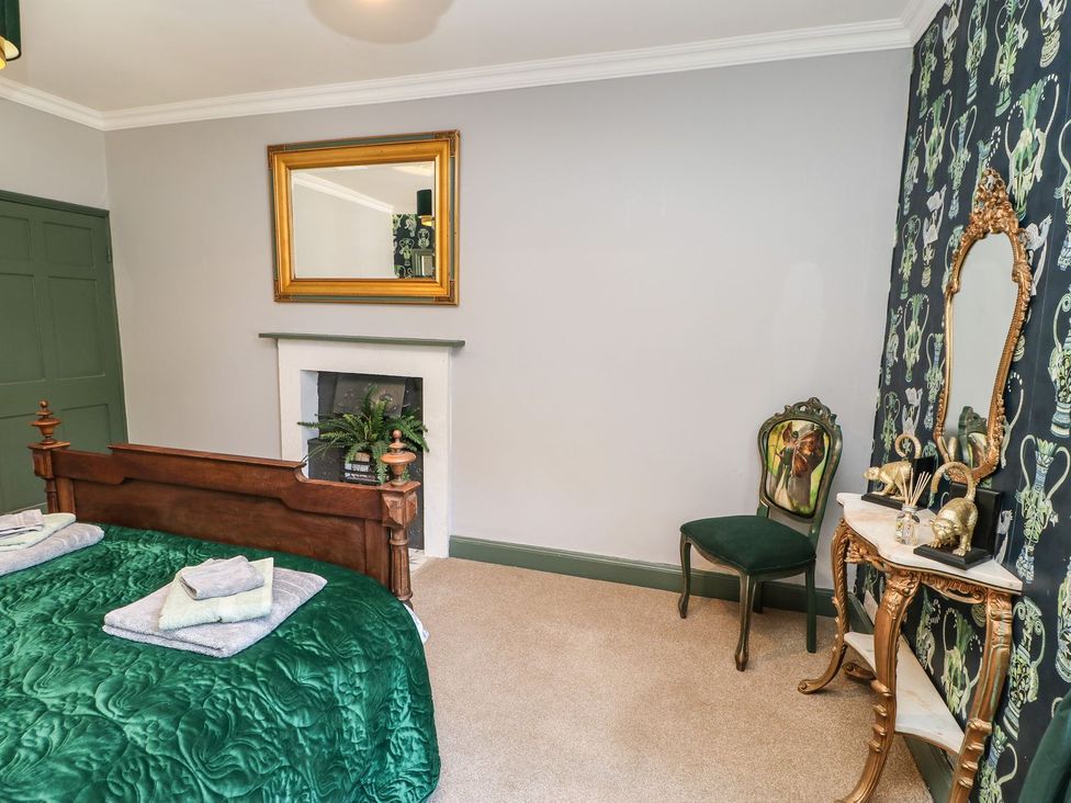 A bedroom with a bed and mirror at The Smithy in Barnard Castle
