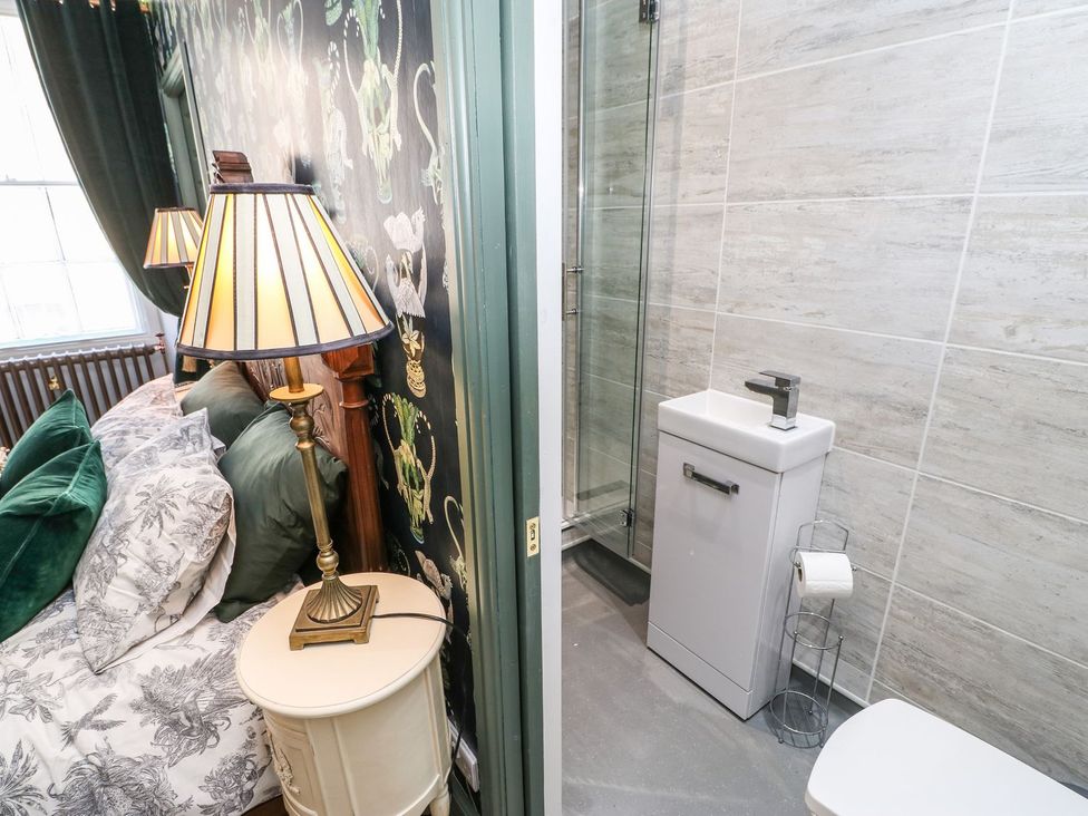 A bedroom with a bed and an adjoining bathroom at The Smithy in Barnard Castle