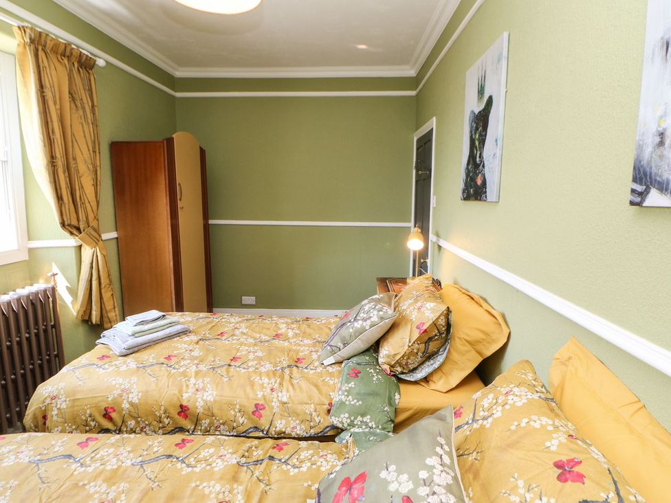 A bedroom with two beds and a wardrobe at The Smithy in Barnard Castle