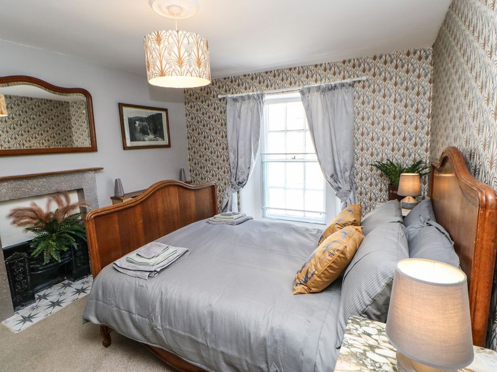 A bedroom with a bed and a fireplace at The Smithy in Barnard Castle