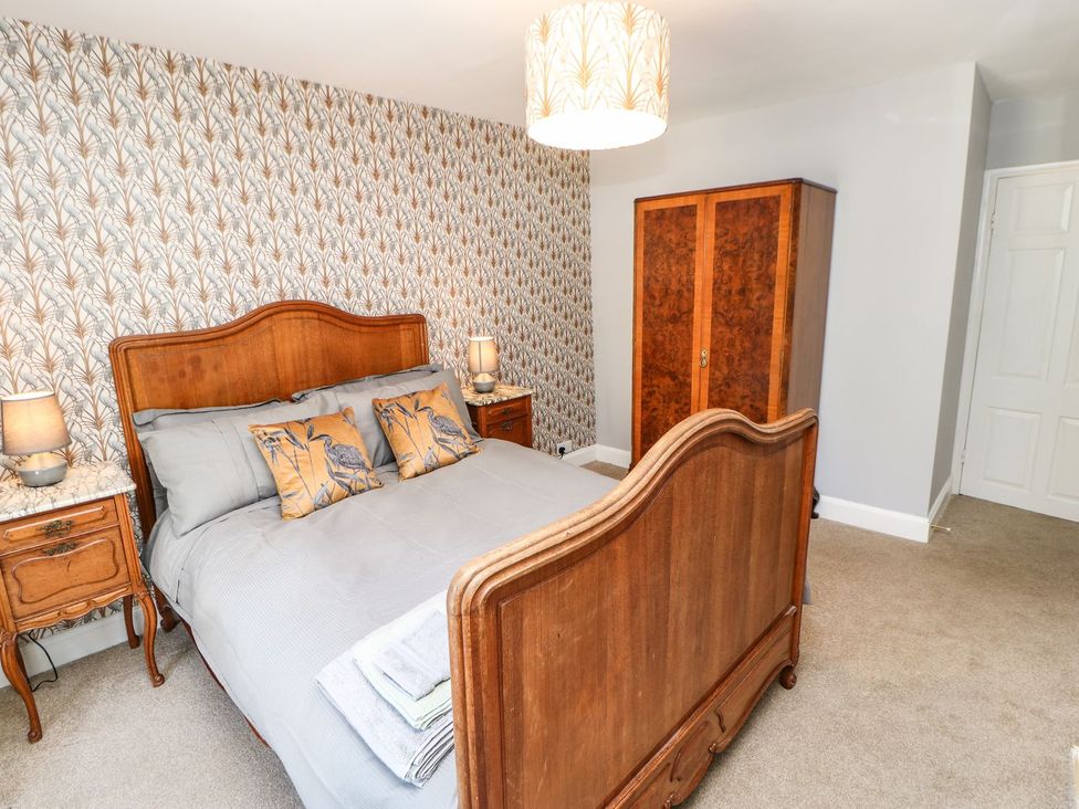 A bedroom with a bed, nightstands, and a wardrobe at The Smithy in Barnard Castle