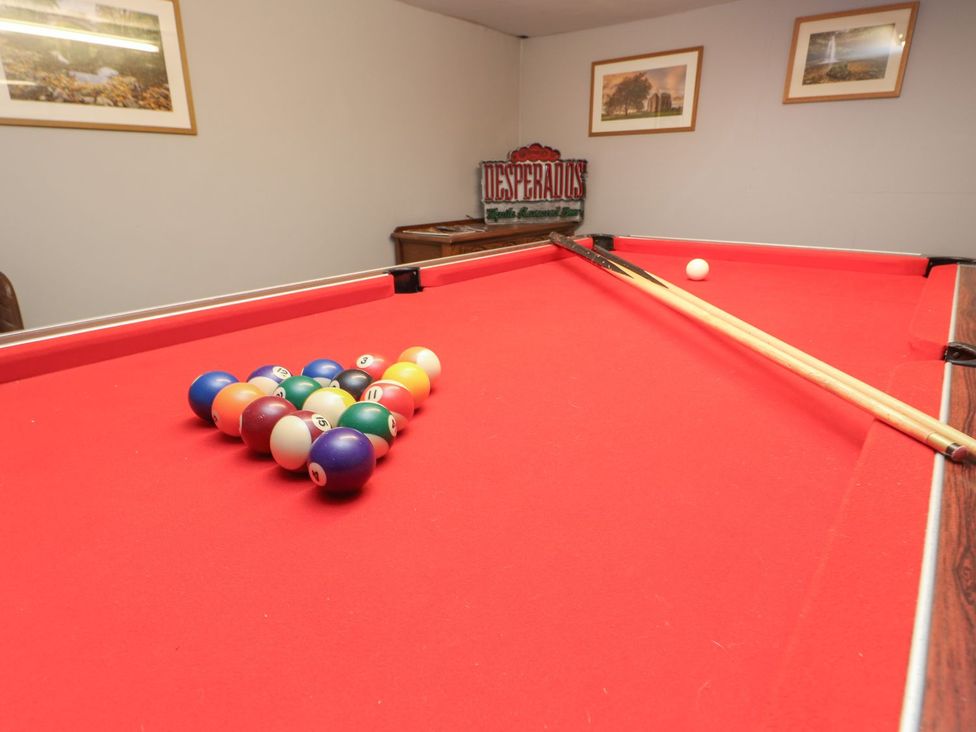 A pool table with balls arranged and cue sticks at The Smithy in Barnard Castle