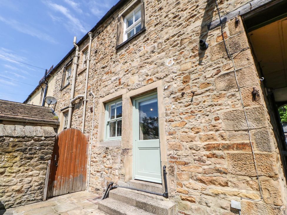An exterior view of a stone house with a green door at The Smithy in Barnard Castle