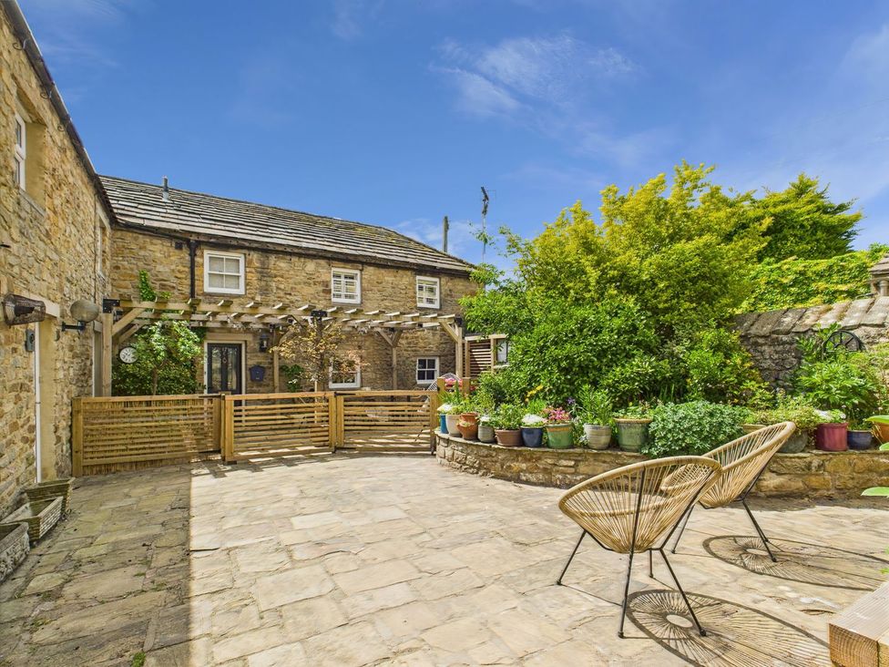 An outdoor area with stone building and chairs at The Smithy in Barnard Castle