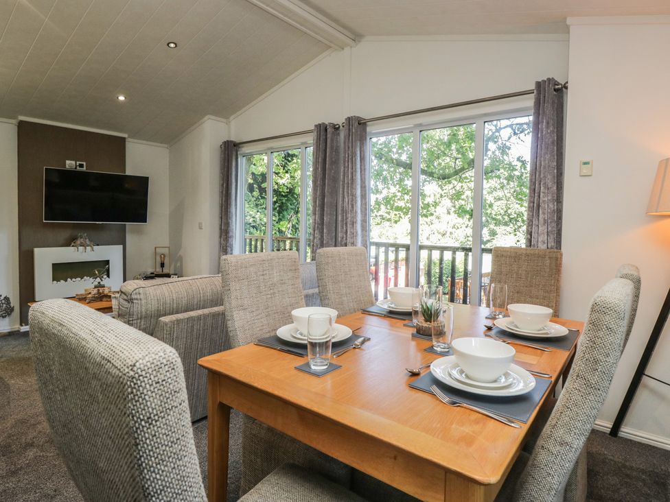 A dining room with a table set for meals at Treetops, Beech Hill 13, Fallbarrow Park near Bowness-On-Windermere