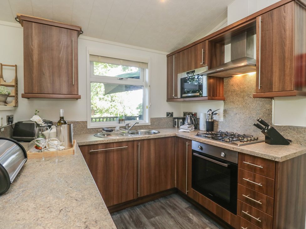 A kitchen with cabinets and appliances at Treetops, Beech Hill 13, Fallbarrow Park near Bowness-On-Windermere