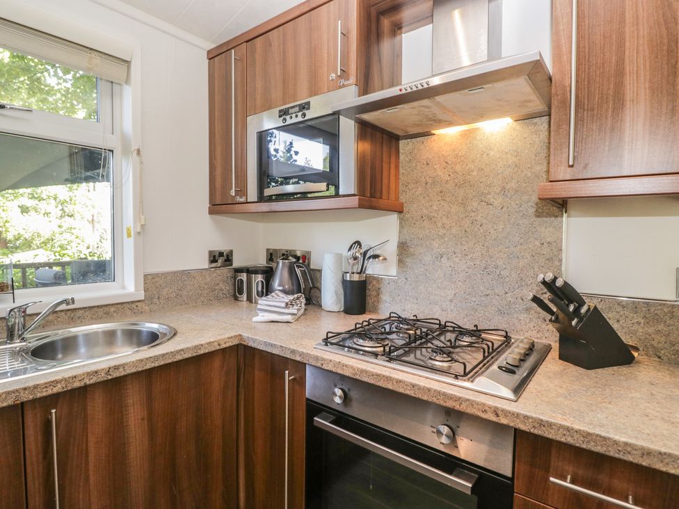 A kitchen with a sink, gas stove, and microwave at Treetops Beech Hill 13 ,Fallbarrow Park near Bowness-On-Windermere