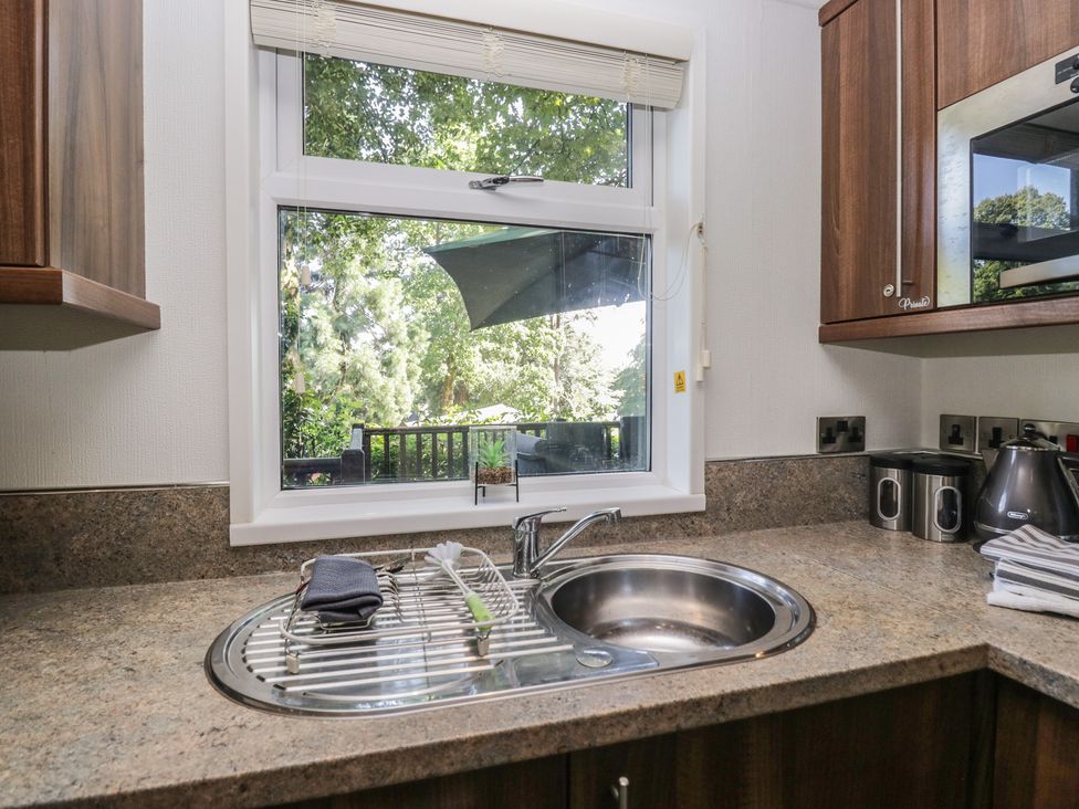 A kitchen with a sink and dish rack at Treetops, Beech Hill 13, Fallbarrow Park near Bowness-On-Windermere