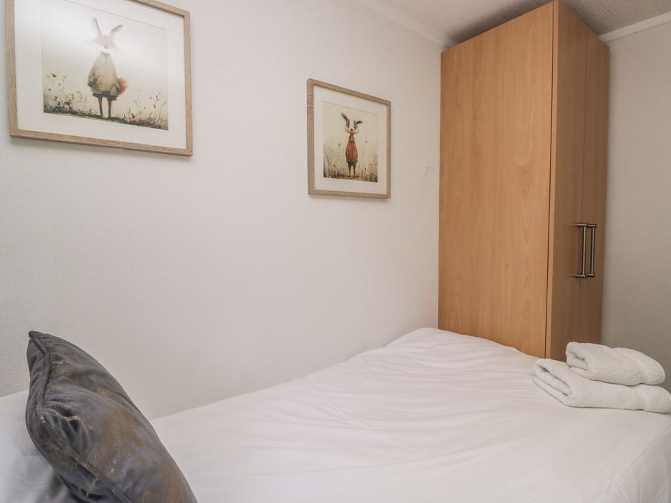 A bedroom with a bed and wardrobe at Treetops Beech Hill 13 ,Fallbarrow Park near Bowness-On-Windermere