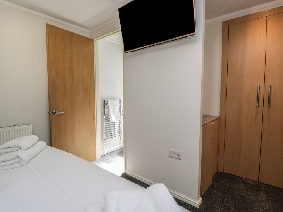 A bedroom with a television and wardrobe at Treetops Beech Hill 13 ,Fallbarrow Park near Bowness-On-Windermere
