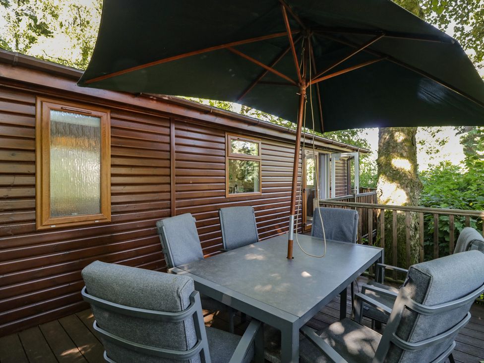 An outdoor seating area with table and chairs at Treetops Beech Hill 13, Fallbarrow Park near Bowness-On-Windermere