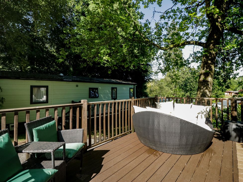 An outdoor area with a sofa, chair, and table at Treetops Beech Hill 13, Fallbarrow Park near Bowness-On-Windermere