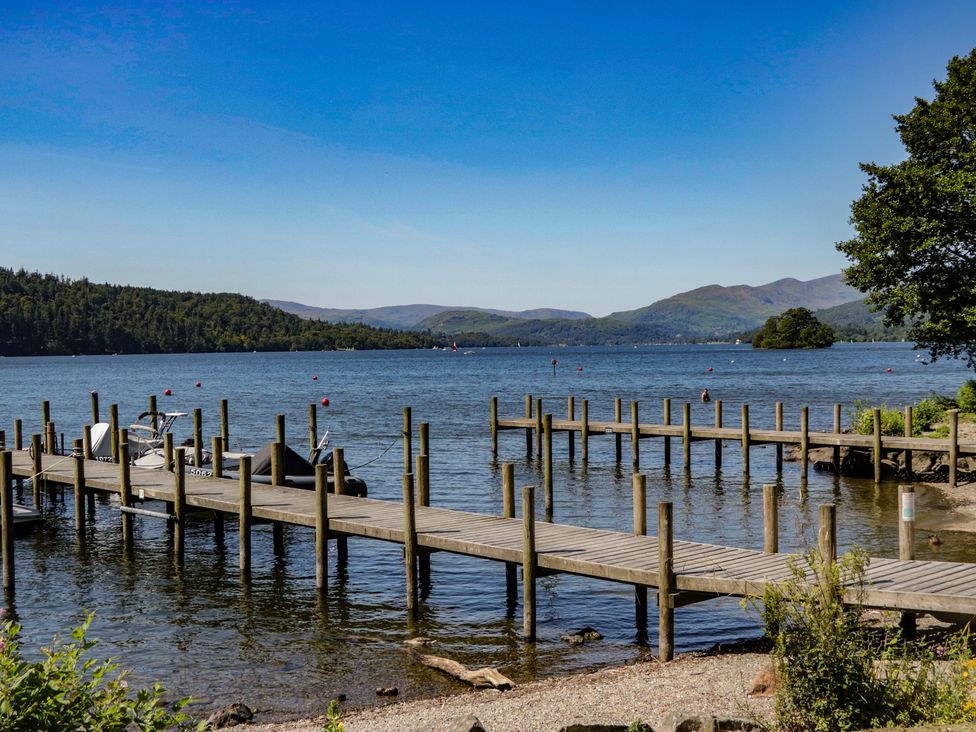 A pier extend into the lake with boats at Treetops Beech Hill 13, Fallbarrow Park near Bowness-On-Windermere