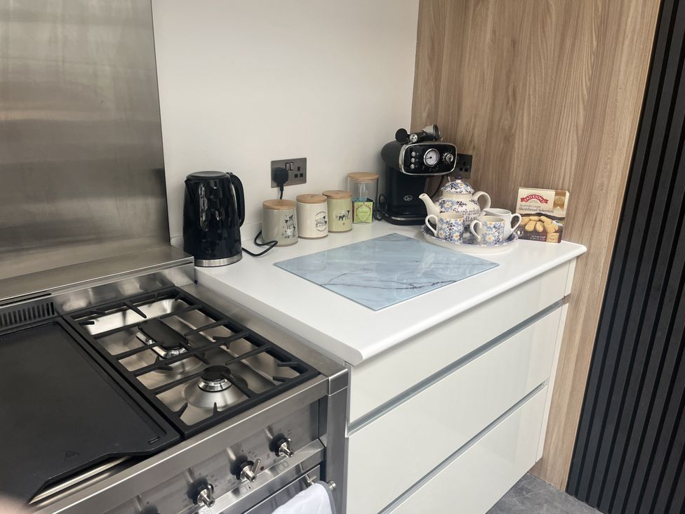Kitchen with stove and coffee machine at Shepherdess Cottage in Moffat