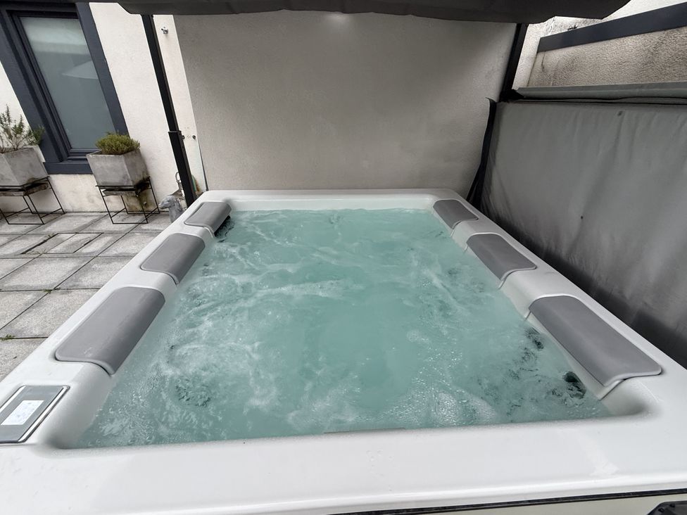 A hot tub with water in an outdoor area at Shepherdess Cottage in Moffat