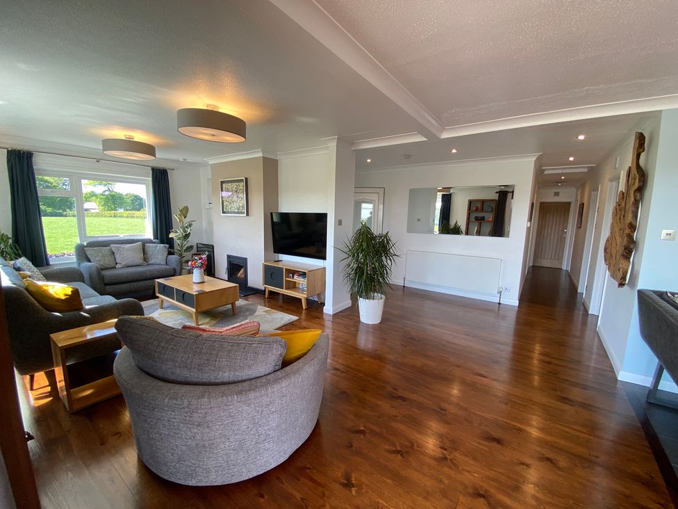 A living room with sofas coffee table tv and plants at Ashlea in Launceston