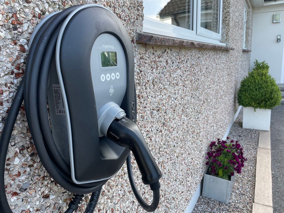 An electric vehicle charger mounted on a wall in an outdoor area at Ashlea in Launceston