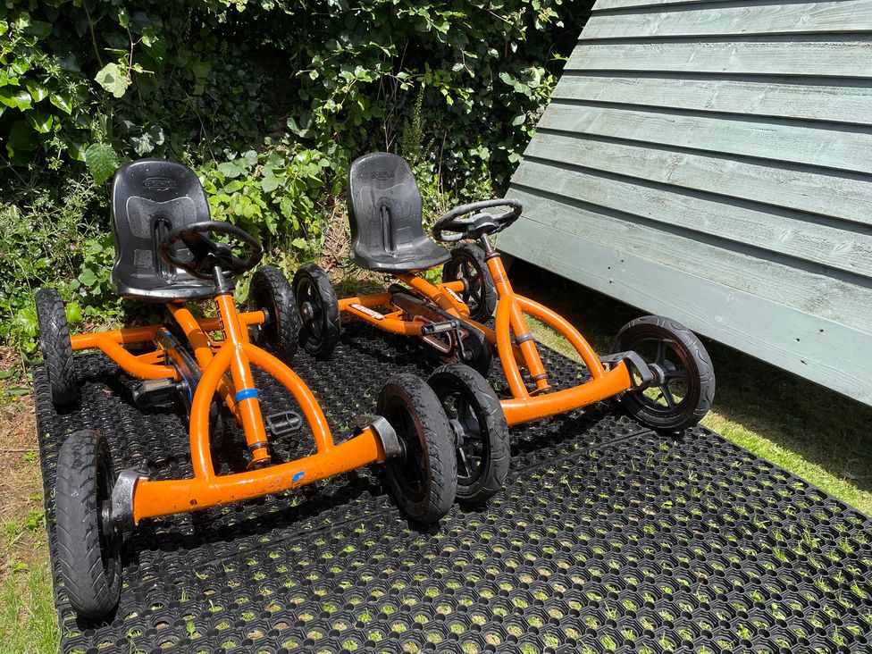 Two orange go-karts on a mat in a garden at Ashlea Launceston