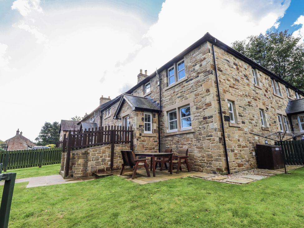 An outdoor area with a stone house and furniture at Crispin in Lucker