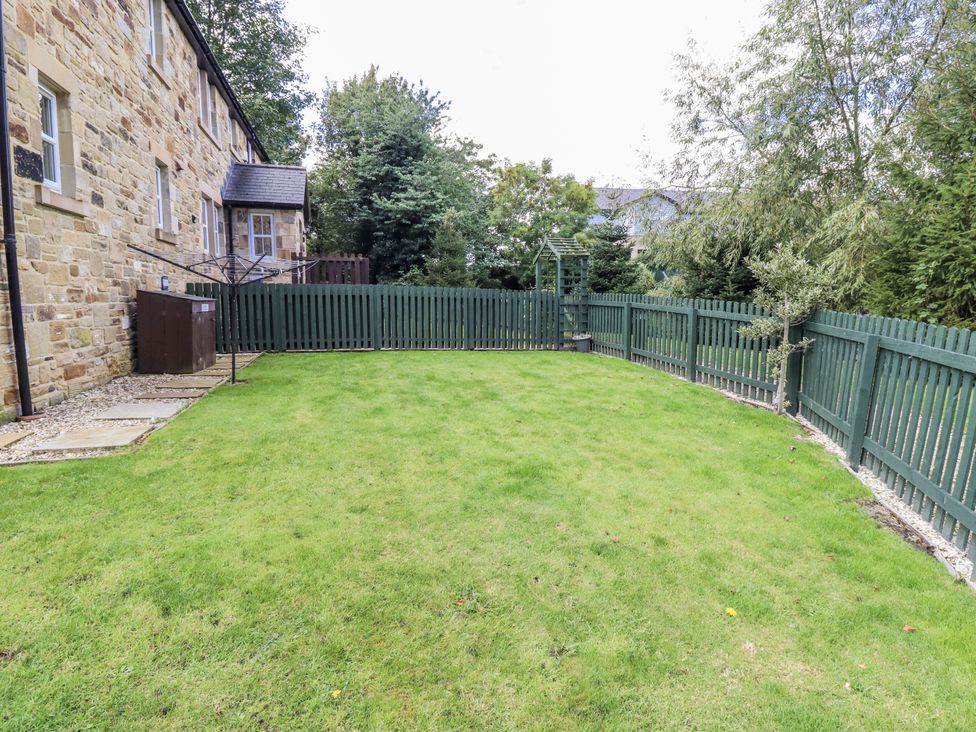 A garden with green grass and a fence at Crispin in Lucker