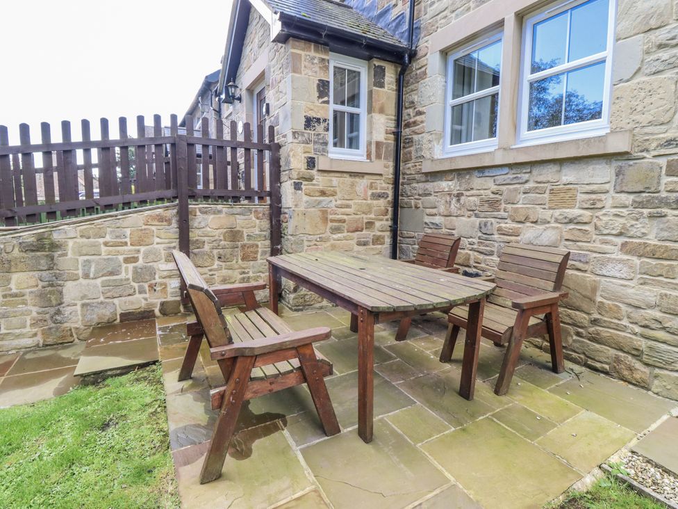An outdoor seating area with a wooden table and chairs at Crispin in Lucker