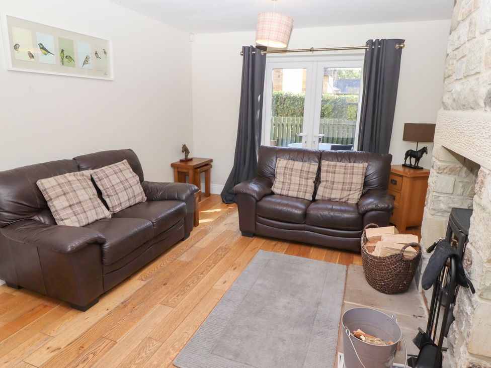 A living room with two sofas and a fireplace at Pippin in Lucker