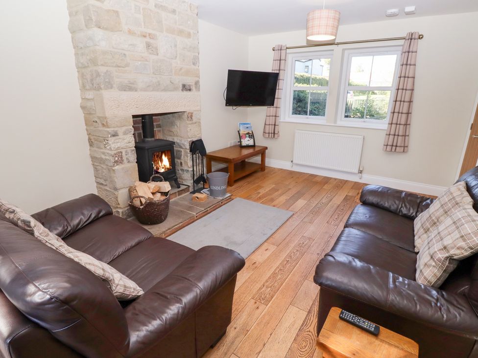 A living room with a fireplace and sofas at Pippin in Lucker