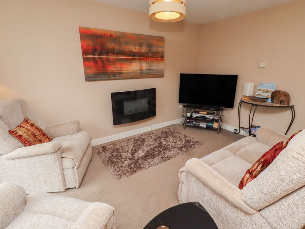 A living room with a television and sofa at Ahoy in Seahouses
