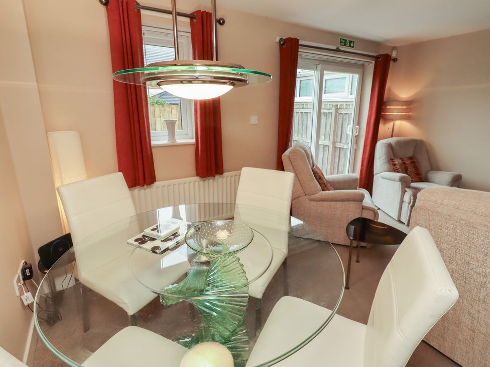 A dining room with a glass table and chairs at Ahoy, Seahouses
