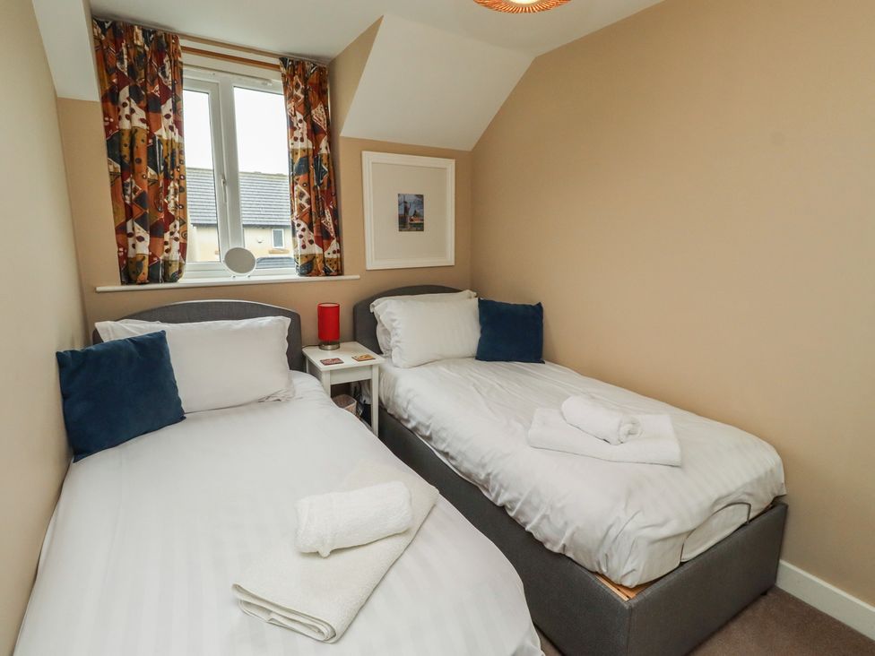 A bedroom with two beds and a window at Ahoy in Seahouses