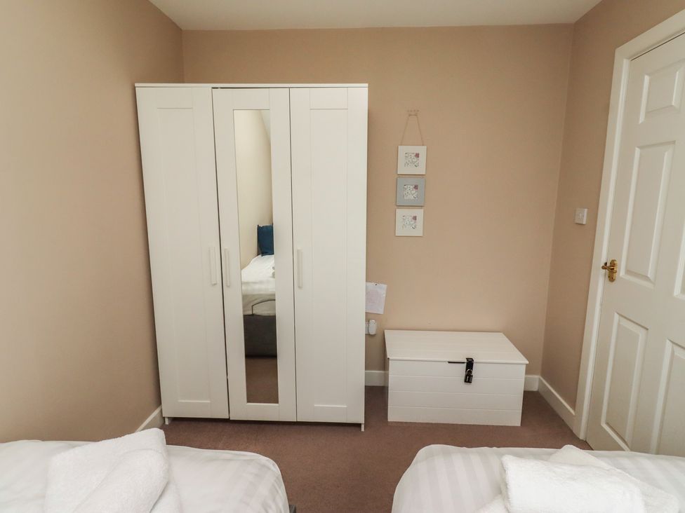 A bedroom with a wardrobe and a blanket box at Ahoy in Seahouses