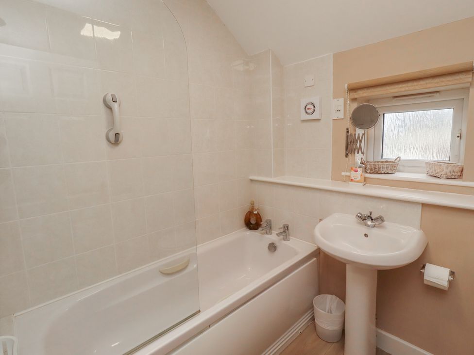 A bathroom with a bathtub and sink at Ahoy in Seahouses