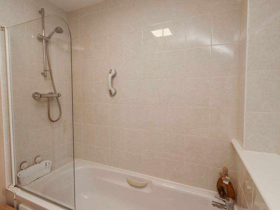 A bathroom with a bathtub and shower facilities at Ahoy in Seahouses