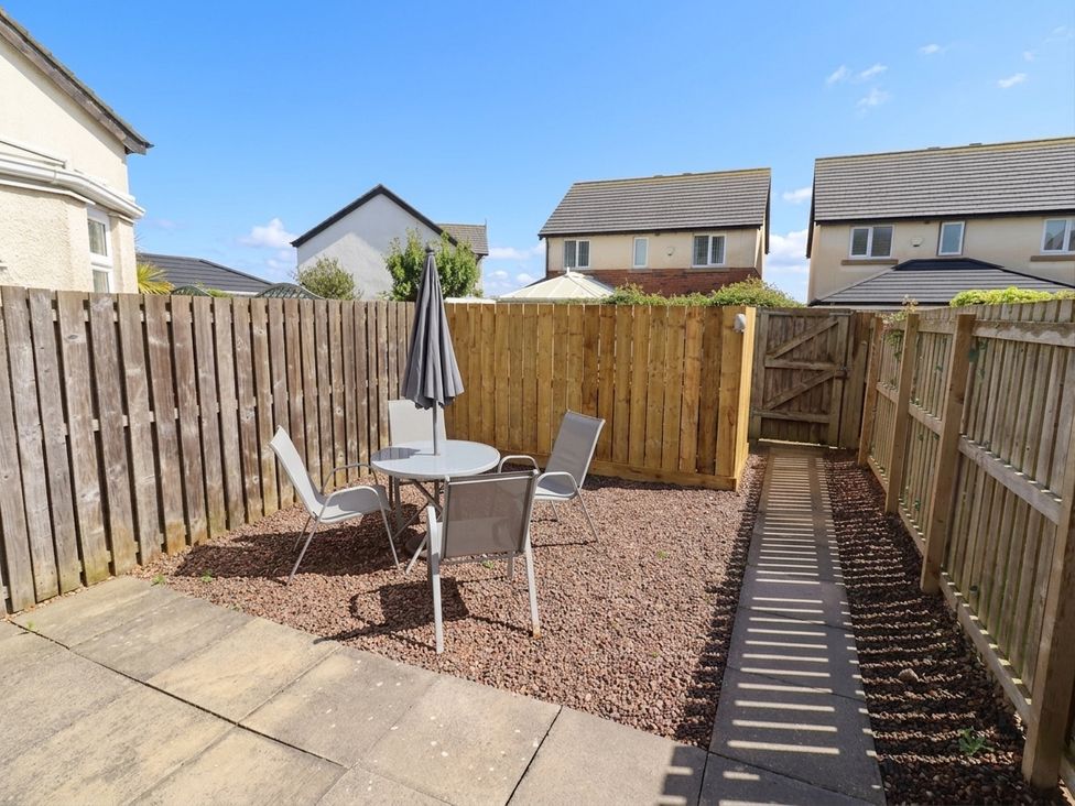 A garden with a table and chairs at Ahoy in Seahouses