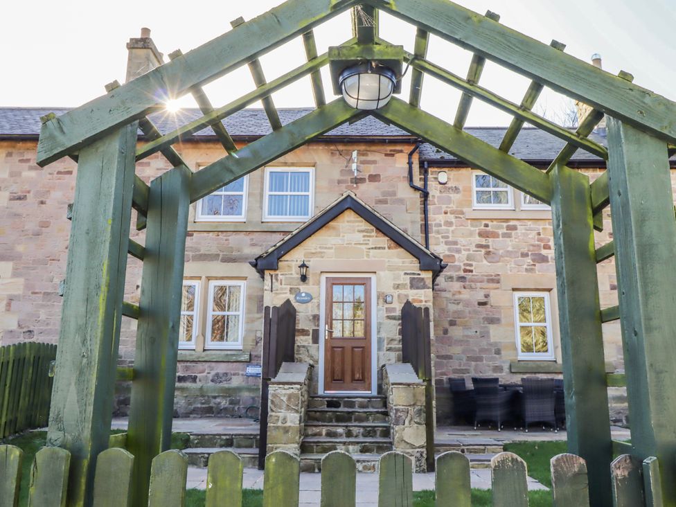 An outdoor view of a house with an archway and seating area at Bramley in Lucker