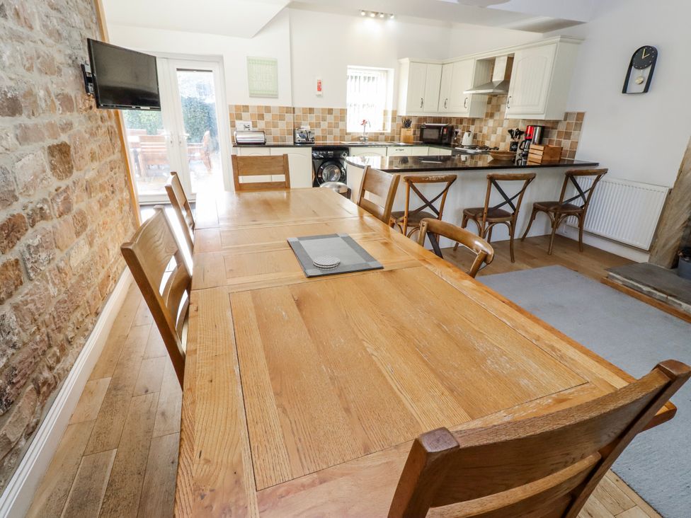 A dining room with a large wooden table at Bramley Lucker
