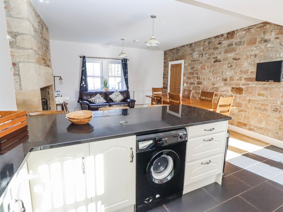 A kitchen with an island and seating area at Bramley in Lucker