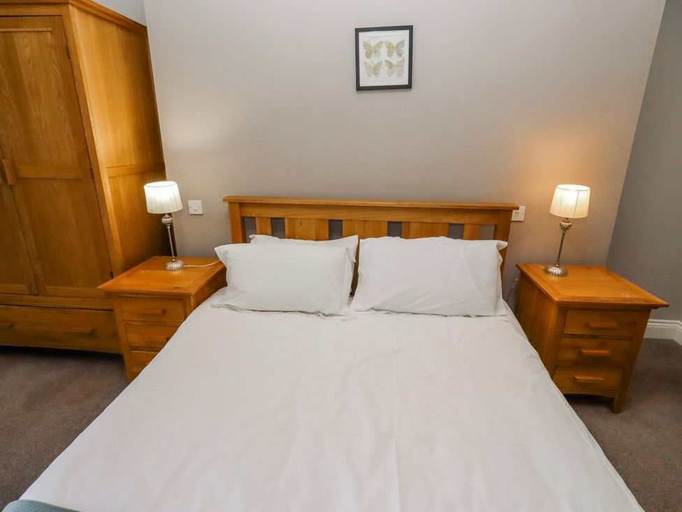 A bedroom with a bed and wooden furniture at Bramley in Lucker