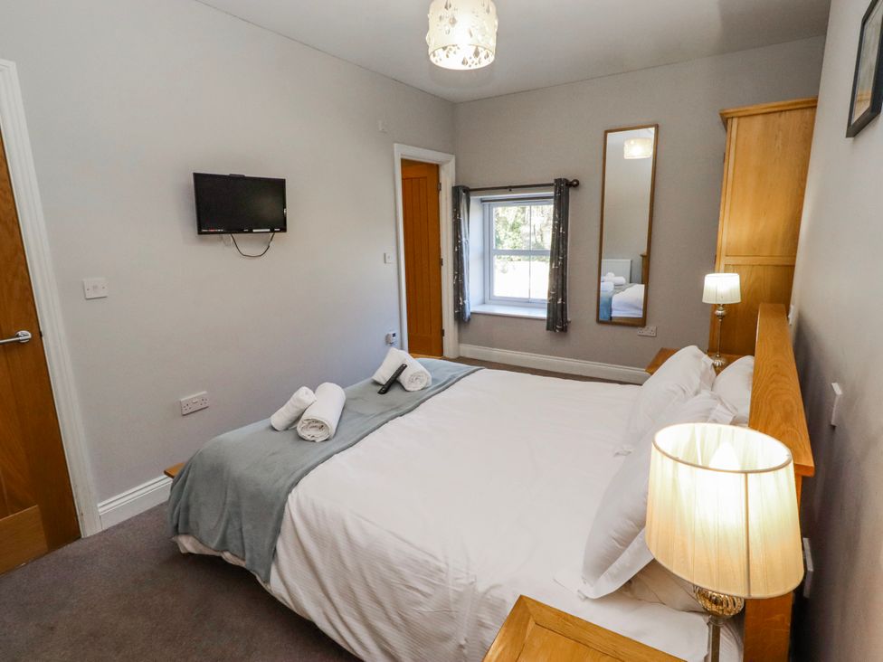 A bedroom with a bed, television, and window at Bramley in Lucker