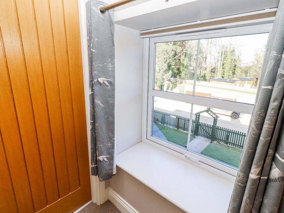 A bedroom window with curtains and a view at Bramley in Lucker
