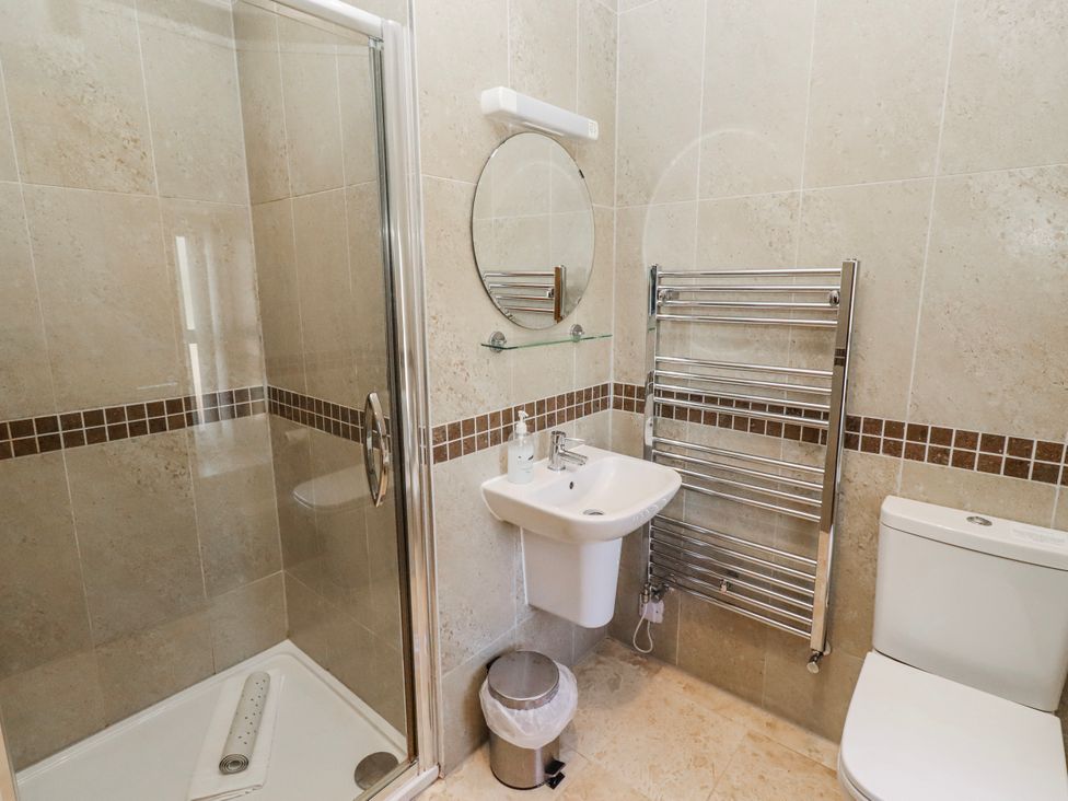 A bathroom with a shower, sink, mirror, and toilet at Bramley in Lucker