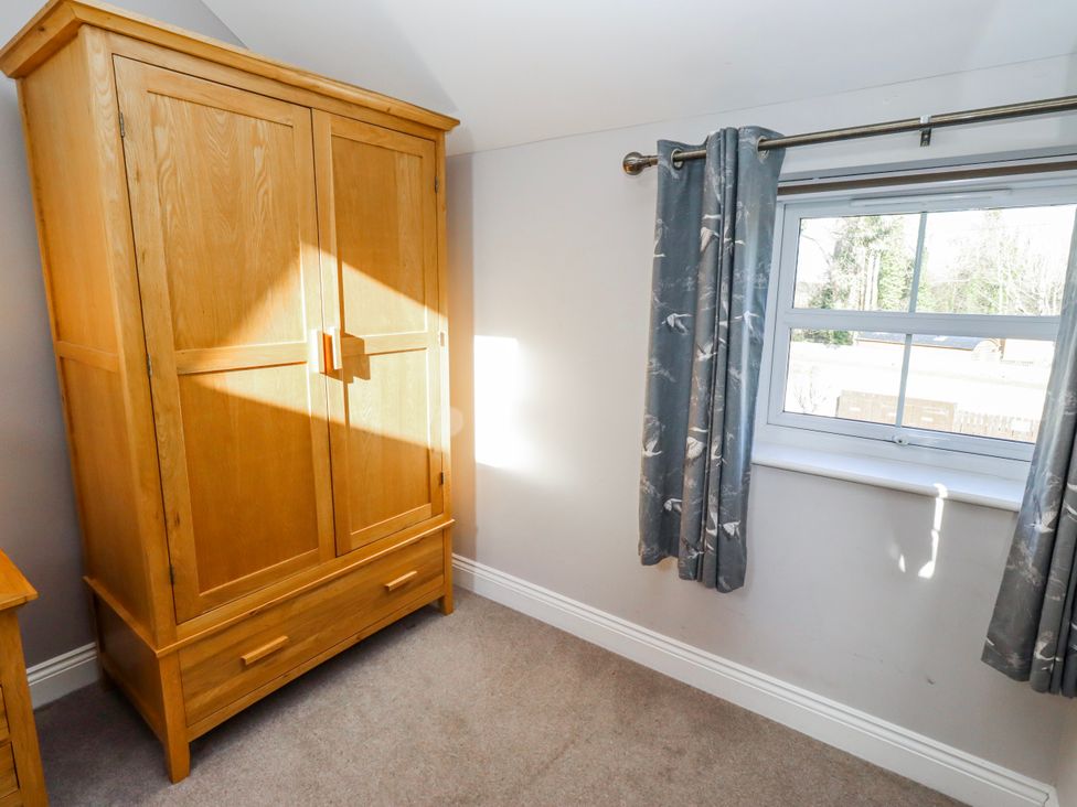 A bedroom with a wardrobe and a window at Bramley in Lucker