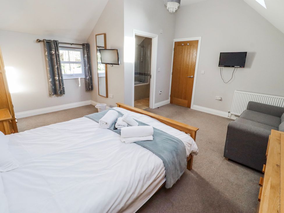 A bedroom with a bed, couch and TV at Bramley in Lucker