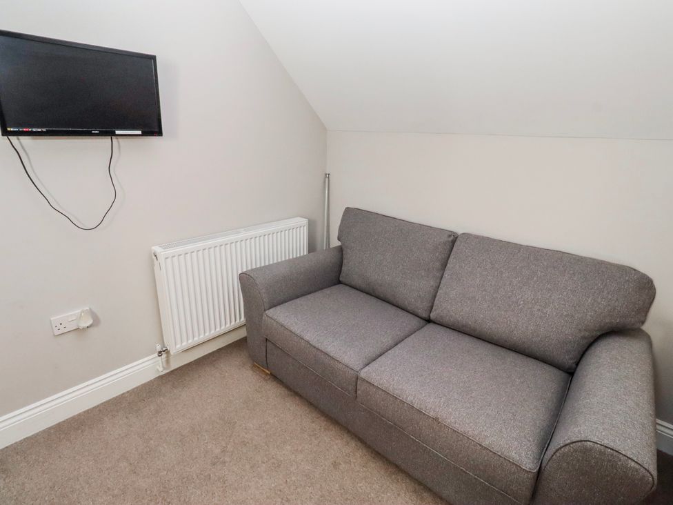 A living room with a sofa and a television at Bramley in Lucker