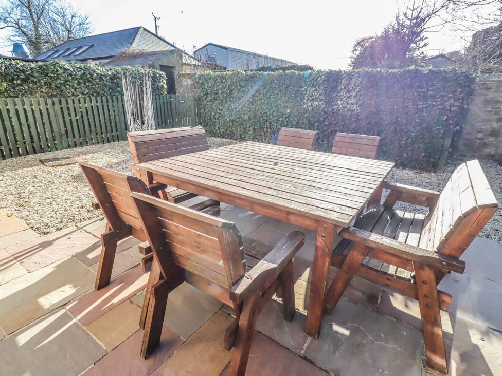 A garden with a wooden table and chairs at Bramley in Lucker