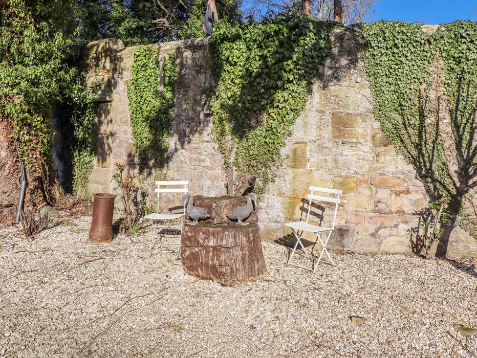 A garden with two chairs and a table made of a stump at Bramley in Lucker